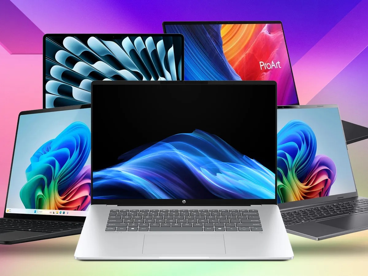 Two business laptops on a desk with a notebook and coffee cup, professional office workspace